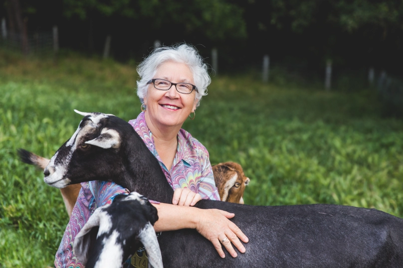A woman hugging a goat