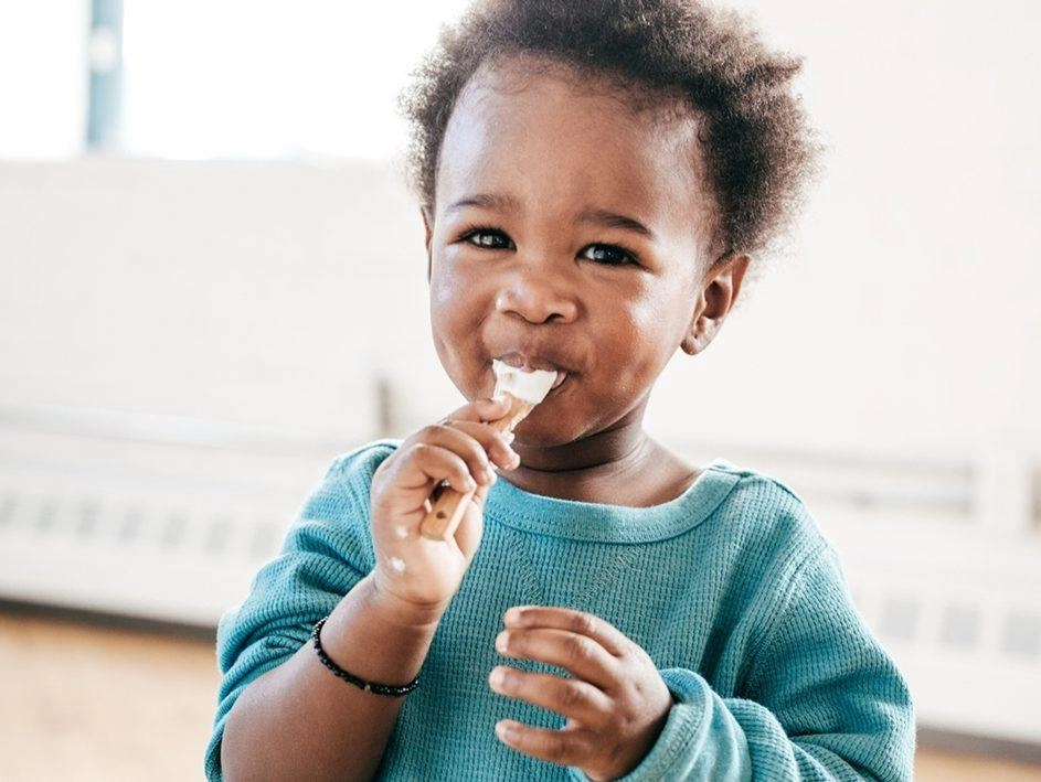 a baby enjoying a spoonful of yogurt